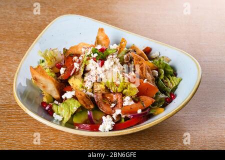 Fattoush est une salade Levantine faite de morceaux de khubz grillés ou frits, combinés avec des légumes verts et autres légumes, tels que des radis et des tomates Banque D'Images