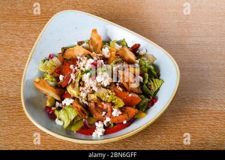 Fattoush est une salade Levantine faite de morceaux de khubz grillés ou frits, combinés avec des légumes verts et autres légumes, tels que des radis et des tomates Banque D'Images