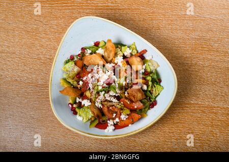 Fattoush est une salade Levantine faite de morceaux de khubz grillés ou frits, combinés avec des légumes verts et autres légumes, tels que des radis et des tomates Banque D'Images