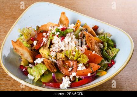 Fattoush est une salade Levantine faite de morceaux de khubz grillés ou frits, combinés avec des légumes verts et autres légumes, tels que des radis et des tomates Banque D'Images