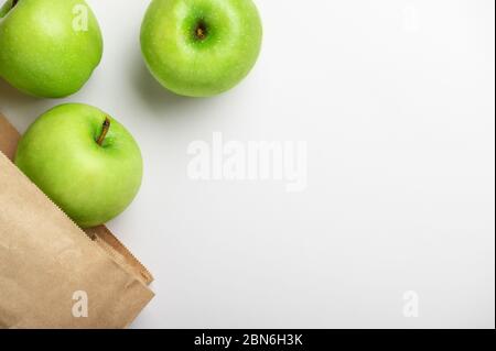 Vue de dessus des pommes dans un sac en papier sur fond blanc avec ombre. Produits écologiques. Aliments naturels. Fruits juteux. Vitamines pour les gens. Vert mûr a Banque D'Images