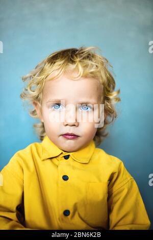 Adorable petit garçon doux avec des cheveux dorés et des yeux bleus Banque D'Images