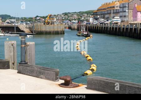 Dragage du port de West Bay près de Bridport, Dorset, Angleterre, Royaume-Uni. Banque D'Images