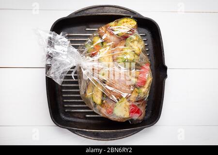 Légumes non cuits avec morceaux de viande sur une casserole dans le sac de cuisson du four. Vue de dessus . Banque D'Images