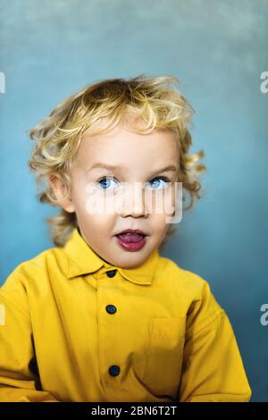 Adorable petit garçon doux avec des cheveux dorés et des yeux bleus Banque D'Images