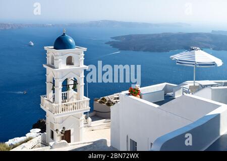 La tour de l'église Anastasi et parasol avec l'océan et les îles en arrière-plan, un jour ensoleillé sans nuages, Imerovigli, Santorini, Grèce Banque D'Images