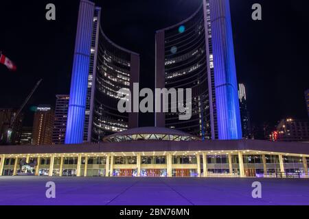 L'hôtel de ville de Toronto vu en violet, à l'appui des travailleurs de l'accueil qui luttent contre la maladie de COVID-19 ￼, la pandémie mondiale de coronavirus. Banque D'Images
