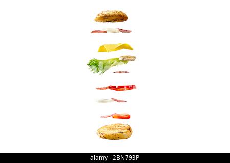 sandwich volant. Couches volantes de sandwich. Patty, jambon, fromage et légumes bien rôtis entre deux moitiés d'un. Concept de la cuisine américaine du petit déjeuner. Banque D'Images