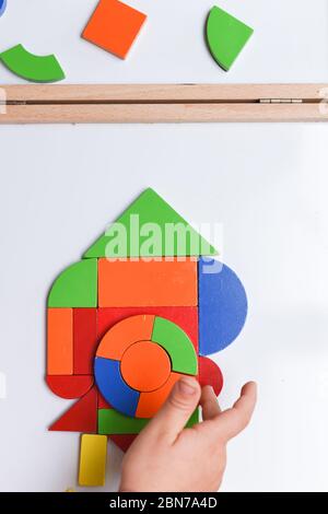 Enfant jouant avec un puzzle coloré en forme de jouet pour apprendre à la maison Banque D'Images