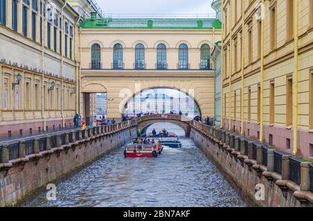 Saint-Pétersbourg, Russie, 3 août 2019 : des bateaux voguent le long du canal d'hiver jusqu'à l'arche du pont de l'Hermitage et de la rivière Neva entre les bâtiments de l'Hermitage Banque D'Images