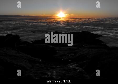 Lever du soleil, sur un tapis de nuages, au sommet du sommet du drapeau, Parc national Serra do Caprao, Minas Gerais, Brésil Banque D'Images