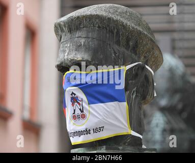 Mayence, Allemagne. 13 mai 2020. Le buste de Gutenberg devant le musée de Gutenberg est revêtu d'une porte-bouche de la Garde de maüz des sacoches. Les restaurants et les pubs de Rhénanie-Palatinat ont été autorisés à rouvrir en vertu de réglementations strictes depuis le 13 mai 2020. Crédit : Arne Dedert/dpa/Alay Live News Banque D'Images