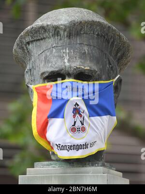 Mayence, Allemagne. 13 mai 2020. Le buste de Gutenberg devant le musée de Gutenberg est revêtu d'une porte-bouche de la Garde de maüz des sacoches. Les restaurants et les pubs de Rhénanie-Palatinat ont été autorisés à rouvrir en vertu de réglementations strictes depuis le 13 mai 2020. Crédit : Arne Dedert/dpa/Alay Live News Banque D'Images