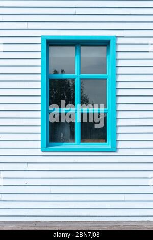 Côté d'un bâtiment en panneaux de rideau avec fenêtre, peint en bleu. Banque D'Images