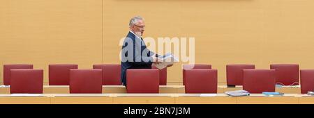 Munich, Allemagne. 13 mai 2020. Joachim Herrmann (CSU), ministre de l'intérieur de Bavière, passe devant les présidents pendant la session du Parlement bavarois à travers le banc gouvernemental vide. Les thèmes de la session de 13.05.2020 comprennent un changement de la loi sur l'utilisation des contributions des centres de santé pour les transports publics et les contrôles actuels aux frontières à la suite de la pandémie de Corona. Crédit : Peter Kneffel/dpa/Alay Live News Banque D'Images