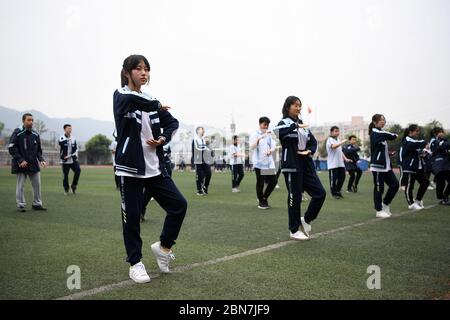 Chongqing. 13 mai 2020. Les élèves apprennent le Tai-chi lors d'un cours de gymnastique dans une école intermédiaire de la municipalité de Chongqing, dans le sud-ouest de la Chine, le 13 mai 2020. Les écoles de Chongqing ont progressivement repris des cours de gymnastique, avec une protection adéquate contre les épidémies pour les élèves. Crédit: Tang Yi/Xinhua/Alay Live News Banque D'Images
