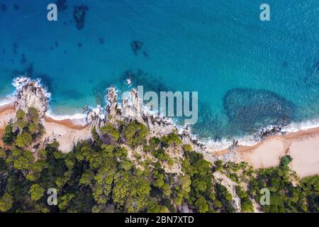 vue aérienne du littoral avec plage et criques d'eaux turquoise entourées de falaises couvertes d'arbres, concept de style de vie d'aventure Banque D'Images