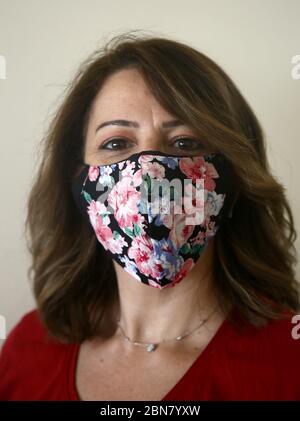 Beyrouth, Liban. 13 mai 2020. Ihsan, 52 ans, pose dans un masque personnalisé au milieu de la pandémie du coronavirus, qui a forcé plusieurs créateurs de mode à fermer leurs entreprises. Malgré la crise, les designers libanais ont rapidement trouvé une nouvelle façon de rester occupés en créant des masques tendance pour le visage, attirant leurs clients avec des motifs colorés et uniques. Crédit : Marwan Naamani/dpa/Alay Live News Banque D'Images