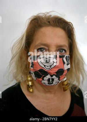 Beyrouth, Liban. 13 mai 2020. Reine, 63 ans, pose dans un masque personnalisé au milieu de la pandémie du coronavirus, qui a forcé plusieurs créateurs de mode à fermer leurs entreprises. Malgré la crise, les designers libanais ont rapidement trouvé une nouvelle façon de rester occupés en créant des masques tendance pour le visage, attirant leurs clients avec des motifs colorés et uniques. Crédit : Marwan Naamani/dpa/Alay Live News Banque D'Images