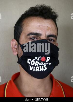 Beyrouth, Liban. 13 mai 2020. Zaki, 29 ans, pose dans un masque personnalisé au milieu de la pandémie du coronavirus, qui a forcé plusieurs créateurs de mode à fermer leurs entreprises. Malgré la crise, les designers libanais ont rapidement trouvé une nouvelle façon de rester occupés en créant des masques tendance pour le visage, attirant leurs clients avec des motifs colorés et uniques. Crédit : Marwan Naamani/dpa/Alay Live News Banque D'Images