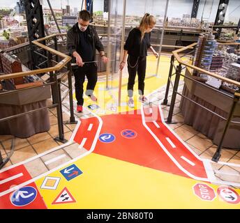 Hambourg, Allemagne. 13 mai 2020. Les employés de Miniatur Wunderland utilisent une règle pliante pour ajuster les murs de protection transparents aux règles de distance requises lors d'un essai avec 200 visiteurs. Après des semaines de fermeture en raison de la pandémie de Corona, le modèle de chemin de fer de Hambourg veut rouvrir lentement pour les visiteurs. Les fans de chemin de fer pourront visiter le plus grand modèle de chemin de fer au monde à partir de mai 20. Credit: Christian Charisius/dpa/Alay Live News Banque D'Images