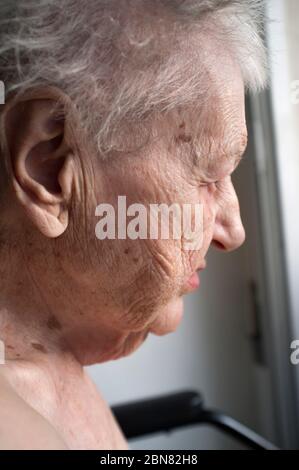 portrait d'une vieille femme solitaire triste et pensive, qui regarde par la fenêtre Banque D'Images