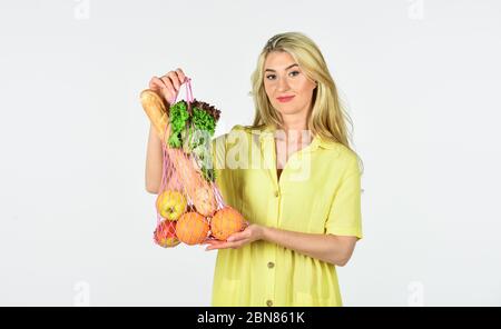 préparer des aliments sains. Femme tient sac à corde avec des fruits et du pain. Concept zéro déchet. Fille en robe avec sac cabas isolé sur blanc. Sac avec épicerie. Sac écologique réutilisable pour les achats. Banque D'Images