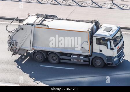 Un grand camion à ordures pour transporter les déchets ménagers se déplace le long de l'autoroute de la ville, vue aérienne Banque D'Images