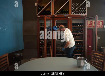 Malaga, Espagne. 13 mai 2020. Un employé nettoyant un cabinet de boissons à l'intérieur de la barre de coquillages « Godoy » avant de rouvrir pendant le confinement partiel après le début de la phase 1 dans certaines villes.l'Espagne passe par un plan de réduction vers une « nouvelle normalité » en assouplissant les mesures résultant de l'épidémie de COVID-19, des villes comme Madrid, Barcelone, Malaga ou Grenade continuent dans la phase 0 en raison des avis épidémiologiques des autorités sanitaires. Crédit: Jesus Merida/SOPA Images/ZUMA Wire/Alay Live News Banque D'Images