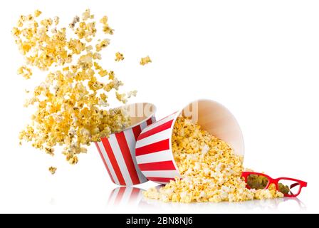 Ensemble de pop-corn volant provenant du seau en papier et de pop-corn dispersé isolé sur du blanc Banque D'Images