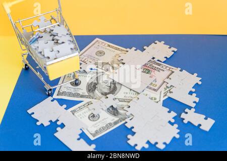 Panier plein de puzzle puzzle sur fond de dollar d'argent, Business solution concept.dollar banknote sous puzzle blanc inachevé. États-Unis ou Banque D'Images