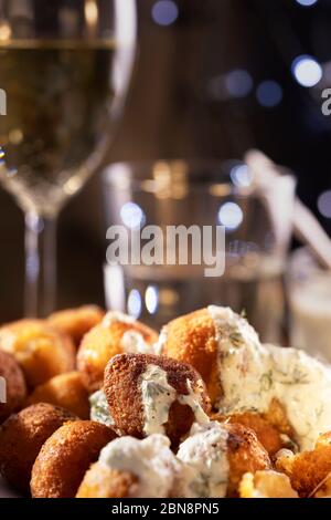 Bâtonnets de fromage mozzarella frits ronds, sauce tzatziki, yaourt, concombres et ail. Verre de vin et d'eau sur fond. Restaurant din Banque D'Images