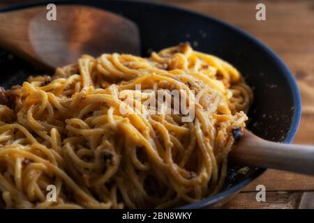 Pâtes alla carbonara au bacon et parmesan à la sauce à la crème dans une poêle sur fond rustique. Savoureuse spaghetti italien cuit carbonara dans une skille Banque D'Images