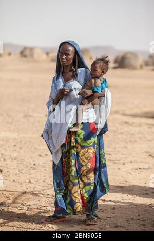 Agadez, Niger. Famille africaine Djerba tribu dans les vêtements traditionnels colorés devant leur maison Sahara désert sur la frontière du Niger et de l'Algérie Banque D'Images