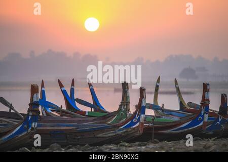 Bateaux colorés sur la rive avec lever du soleil près du pont U Bein, lac Taungthaman près d'Amarapura, Myanmar Banque D'Images