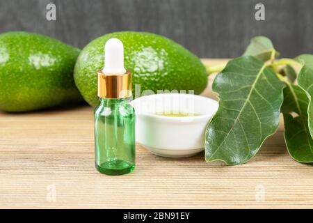 Huile d'avocat cosmétique en bouteille compte-gouttes, maquette. Bouteille en verre. Maquette d'avocat et d'huile d'olive. Bio naturel soin de peau cosmétique. Huile essentielle d'avocat d Banque D'Images