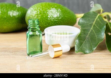 Huile d'avocat cosmétique en bouteille compte-gouttes, maquette. Bouteille en verre. Maquette d'avocat et d'huile d'olive. Bio naturel soin de peau cosmétique. Huile essentielle d'avocat d Banque D'Images