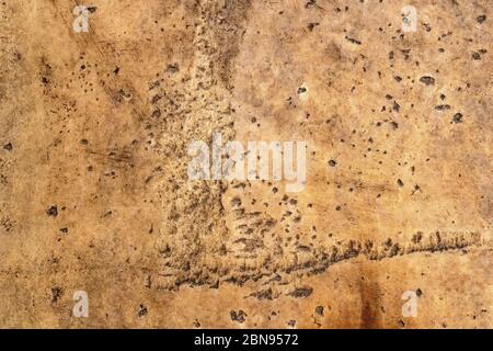 Gratter la surface en pierre érodée boueuse rayée. Maçonnerie endommagée toile de fond unie texturée et rugueuse. Fond en béton brun avec des intempéries et sc Banque D'Images