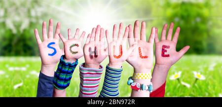 Les mains des enfants Bâtiment de mot Schule signifie école, Grass Meadow Banque D'Images