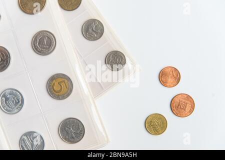 Mise à plat des feuilles et pièces de l'album numismatique. Collection de pièces rares sur le blanc avec espace copie Banque D'Images