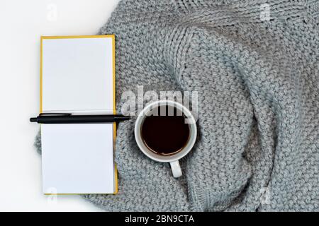 lieu de travail, café en sueur et accessoires d'écriture, bloc-notes. travail à la maison. Concept chaud temps froid. Banque D'Images