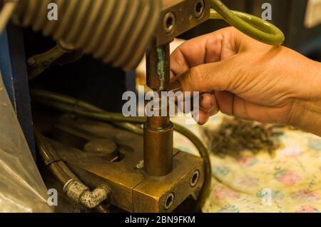 Photo en gros plan de la main d'une femme soudant électroniquement une pièce. Banque D'Images
