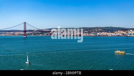Vue panoramique sur Lisbonne, le pont du 25 avril et trois bateaux sur le Tage, vue depuis Almada, Portugal Banque D'Images