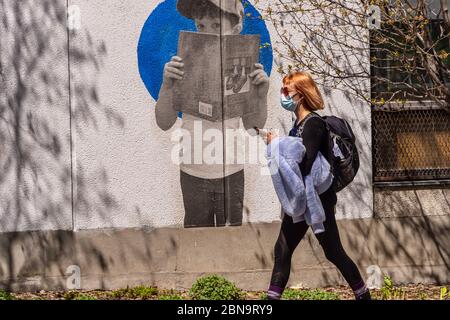 Montréal, CA - 13 mai 2020 : femme avec masque facial pour la protection contre la COVID-19 en descendant la rue Laurier Banque D'Images