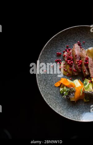 Salade magnifiquement agenlée sur une assiette avec de la viande Banque D'Images