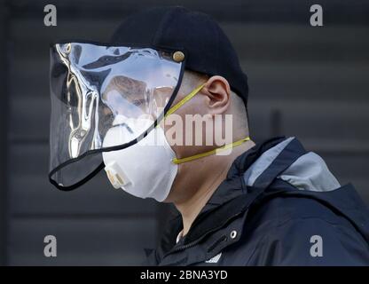 New York, États-Unis. 13 mai 2020. Un homme porte un masque facial en plastique et un masque protecteur lorsqu'il marche dans la rue près du Lincoln Center qui reste fermé en raison de la pandémie COVID-19 à New York le mercredi 13 mai 2020. Une maladie rare semblable à celle de Kawasaki frappe et, dans certains cas, tue des enfants qui ont des anticorps contre le coronavirus. Plus de 22,000 personnes sont mortes après avoir été séropositives pour le coronavirus dans l'État de New York. Photo de John Angelillo/UPI crédit: UPI/Alay Live News Banque D'Images