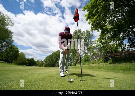 Manchester. 13 mai 2020. Barry Bancroft putt comme il joue une partie de golf pour la première fois en près de deux mois au club de golf de Prestwich comme les membres du public sont autorisés à reprendre la partie de certains sports dans des conditions sociales de distanciation à Manchester, en Grande-Bretagne, le 13 mai 2020. Selon le gouvernement britannique, les gens peuvent faire de l'exercice à l'extérieur autant de fois par jour qu'ils le souhaitent mercredi au lieu d'une seule fois par jour. Crédit : Jon Super/Xinhua/Alay Live News Banque D'Images