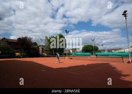 Manchester. 13 mai 2020. Les gens jouent au tennis au Northern Lawn tennis Club car les membres du public sont autorisés à reprendre certains sports dans des conditions sociales de distanciation à Manchester, en Grande-Bretagne, le 13 mai 2020. Selon le gouvernement britannique, les gens peuvent faire de l'exercice à l'extérieur autant de fois par jour qu'ils le souhaitent mercredi au lieu d'une seule fois par jour. Crédit : Jon Super/Xinhua/Alay Live News Banque D'Images