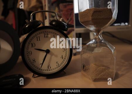 Gros plan d'un réveil et d'un verre de sable la table Banque D'Images