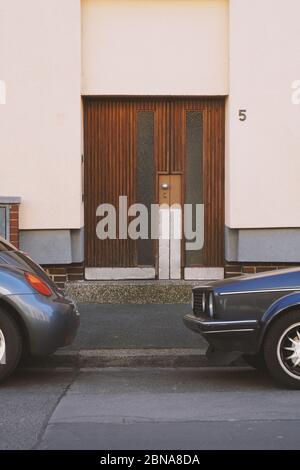 Image verticale d'une porte de bâtiment fermée avec des voitures garées extérieur Banque D'Images